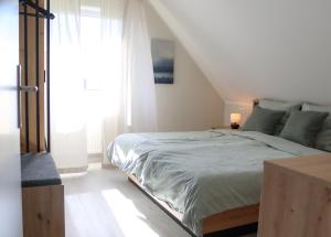 Un dormitorio con una cama grande y una ventana en Ferienwohnung Ostfrieslandliebe, en Südbrookmerland