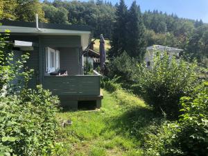 Lindenfels的住宿－Ferienhaus Auszeit，院子里带长凳的绿色房子