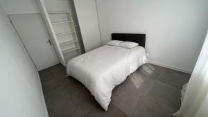 a small bedroom with a white bed and a tiled floor at Magnifique villa haut standing in Gignac