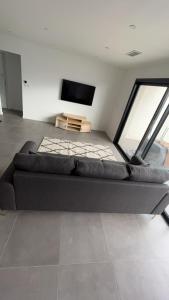 a room with a couch and a tv in it at Magnifique villa haut standing in Gignac