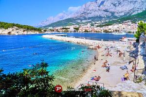 a group of people on a beach in the water at Apartment Vucic in Makarska