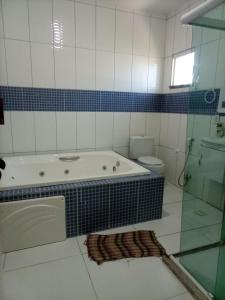 uma casa de banho com banheira e WC em Casa jauá em Camaçari