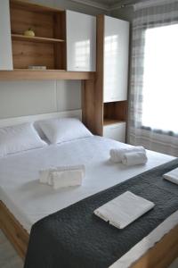 a bedroom with a bed with two towels on it at Oneiropagida House in Sarti