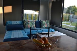 a room with a couch and a bowl of fruit on a table at Oneiropagida House in Sarti