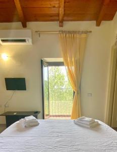 a bedroom with a bed and a large window at Due Passi B&B in Marano Marchesato