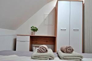 a bedroom with a bed with towels on it at Apartman Tilia in Ravna Gora