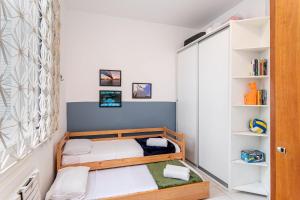 a small bedroom with a bunk bed and shelves at Temporada Bacana - Copacabana e Conforto in Rio de Janeiro