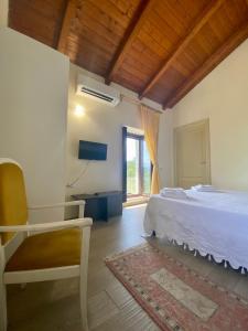 a bedroom with a bed and a chair and a window at Due Passi B&B in Marano Marchesato