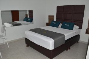 1 dormitorio con 2 camas y almohadas azules en Ayenda Casa Aika Sucre, en Lima