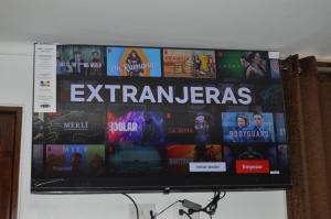 uma televisão de ecrã plano pendurada numa parede em Ayenda Casa Aika Sucre em Lima