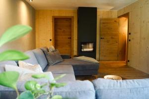 a living room with a blue couch and a fireplace at Das Heuhaus in Börtlingen