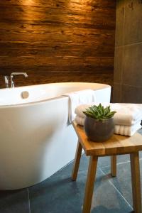 a bathroom with a tub and a table with a plant at Das Heuhaus 