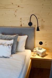 a bed with a lamp and a book on a table at Das Heuhaus 