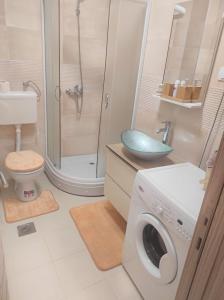 a bathroom with a washing machine and a shower at Bella Lux Centar in Mladenovac +20 photos