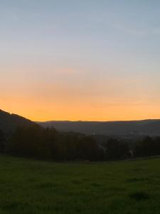 a sunset in a field with a green field at Pension Vyhlídka in Klášterec nad Ohří