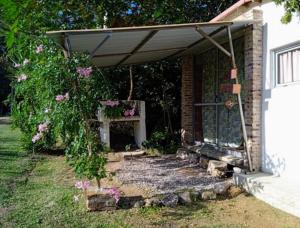 eine Veranda eines Hauses mit Markise und Blumen in der Unterkunft Amor amor in San Luis