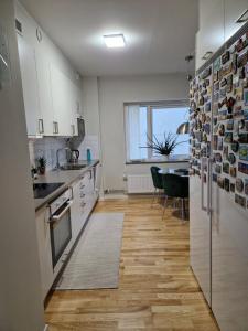 a kitchen with white cabinets and a wooden floor at Homestay - private room in an apartment in Gothenburg