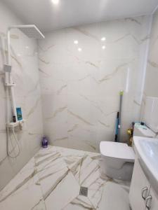 a white bathroom with a toilet and a sink at Apartment near to airport in Sofia