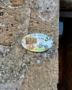 a plate on the side of a stone wall at Civita Secret Lodge in Lubriano