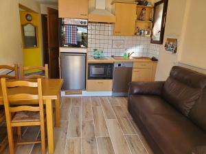 a living room with a couch and a kitchen at Au Paradis des Grillons in Espinasses