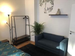 un soggiorno con divano blu e una pianta di Grüne Oase mit Balkon & Netflix I EG a Duisburg