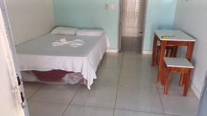 ein kleines Schlafzimmer mit einem Bett und zwei Tischen in der Unterkunft Hotel Gods Time Is The Best in Boa Vista