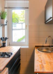 eine Küche mit einem Waschbecken und einem Fenster in der Unterkunft Grüne Oase mit Balkon & Netflix I EG in Duisburg
