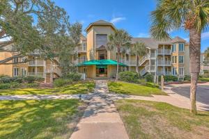 a large apartment building with palm trees in front of it at New Listing! Port O' Call E203-Luxury Ocean View! in Isle of Palms