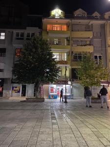 un edificio con gente caminando delante de él por la noche en Hotel Venecia Apartments, en Struga