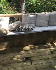 Un sofá con almohadas sobre una terraza de madera. en Casa de ferias, en Trancoso
