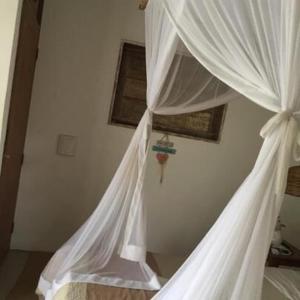 1 dormitorio con 1 cama con cortina blanca en Casa de ferias, en Trancoso