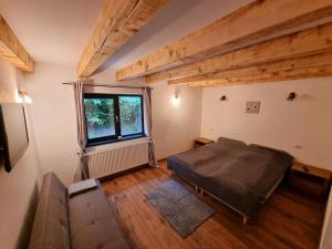 Schlafzimmer mit einem Bett und einem Fenster in der Unterkunft La Izvoare in Clopotiva
