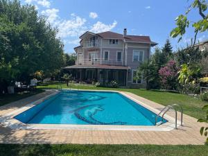 a large swimming pool in front of a house at Villa Elysium in Gebze