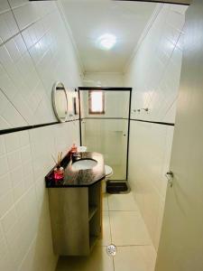 a bathroom with a sink and a shower at Cobertura Piscina Privativa frente e Vista Mar Centro Mongaguá in Mongaguá