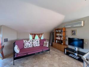 a living room with a purple couch and a flat screen tv at Villa Elysium in Gebze