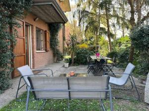 um pátio com uma mesa e cadeiras ao lado de um edifício em Appartamento Immerso nel Verde em Borgo Malpasso