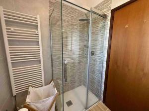 um chuveiro com uma porta de vidro na casa de banho em Appartamento Immerso nel Verde em Borgo Malpasso