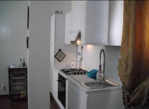 a kitchen with a sink and a stove and white cabinets at Chez moi in Colleverde +19 photos