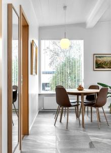 a dining room with a table and chairs and a window at Nes Residence in Reykjavík