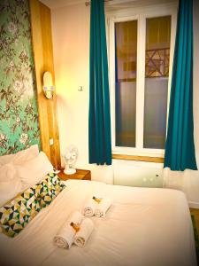 sypialnia z łóżkiem z ręcznikami i oknem w obiekcie Appartement élégant - 2 chambres - 2 salles de bain w Paryżu +12 zdjęć
