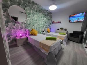 ein Zimmer mit zwei Betten und einem Spiegel in der Unterkunft Apartamento Playa Chica in Las Palmas de Gran Canaria