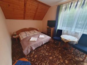 una camera con un letto e una sedia e una finestra di Karkoz a Karpacz