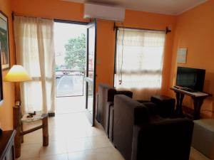 un salon avec un canapé, des fauteuils et une télévision dans l'établissement Costa Posadas, à Posadas