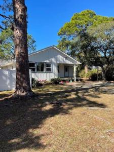 a white house with a tree in front of it at Backroad Blue in St. George Island