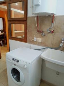 a bathroom with a washing machine and a sink at Costa Posadas in Posadas +5 photos