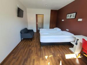 a bedroom with a bed and a blue chair at Studio 22 in Reyðarfjörður