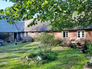 a brick house with chairs and a table in the yard at Ringkøbing Fjord B&B in Skjern