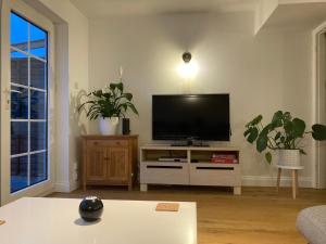 a living room with a flat screen tv on a stand at Pristine 3 Bed Home For Family or Business Stays, Great Location, FREE Parking, Park Views, Sleeps 5! in Ashford