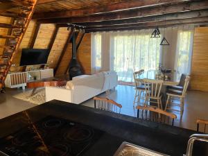 uma cozinha e sala de estar com um sofá e uma mesa em Chalé com VISTA para o vale e Churrasqueira- a 6km do Centro em Ibicaré