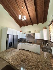 a kitchen with white cabinets and a black refrigerator at Perfect Sunset View in Palm-Eagle Beach